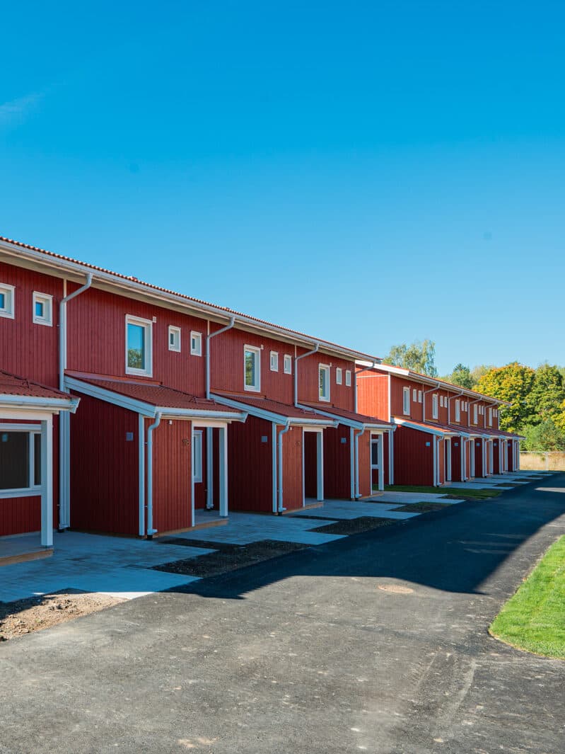 Bostäder utvecklade åt företagskund i Skogstorp, Eskilstuna. Entrébild med röd fasad.